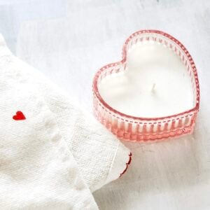 Bougie coulée dans un pot en verre rose en forme de cœur