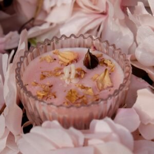 Bougie rose aux pétales de rose séchés dans une coupe en verre ciselé