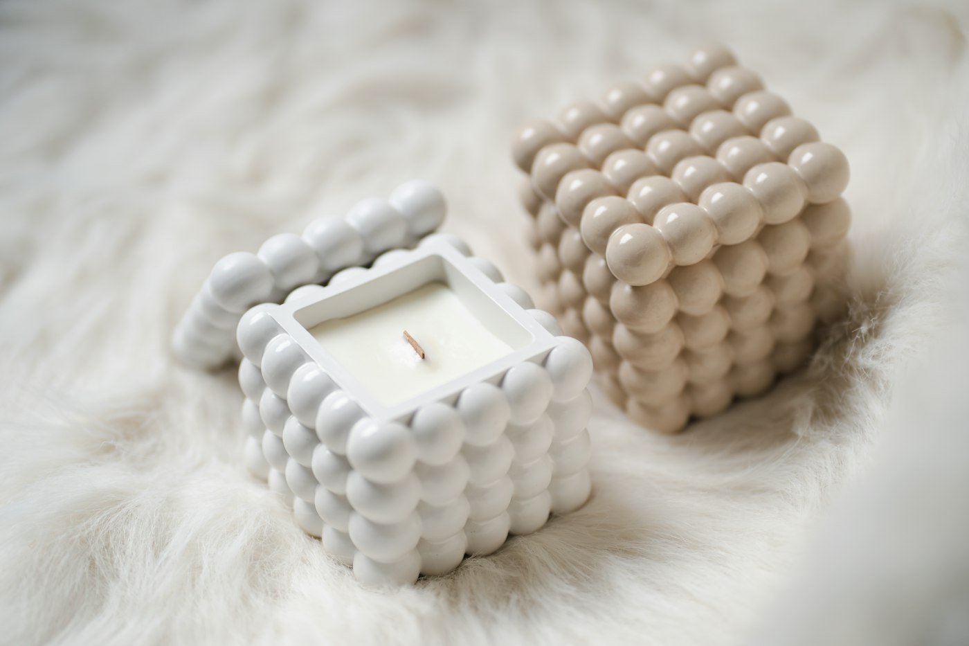 Bougies bulles blanches sur une fourrure crème